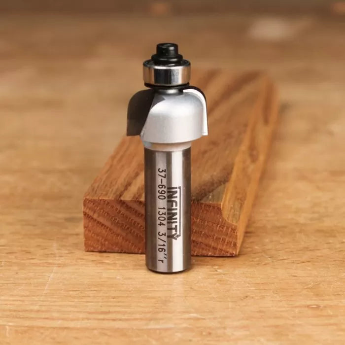 Roundover router bit with bearing on wooden surface, woodworking tool for edge finishing.