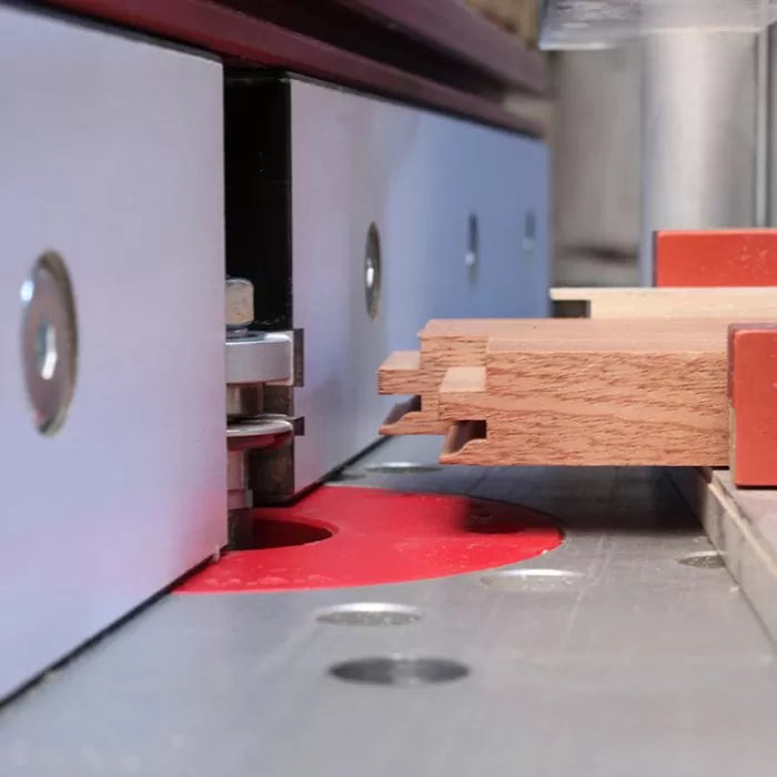 Woodworking router table cutting dovetail joint in hardwood board