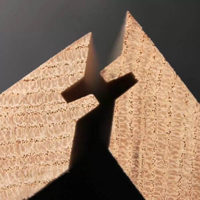 Close-up of two wood pieces joined with a precise lock miter joint for woodworking projects