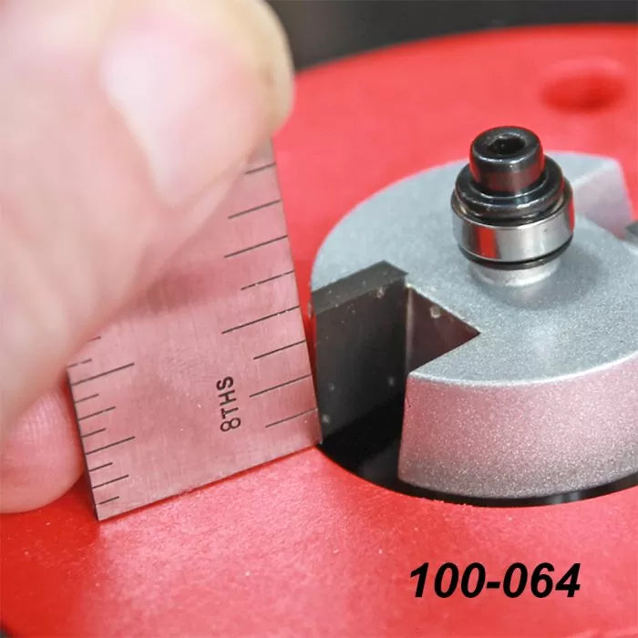 Close-up of a straight edge against a router bit on a red router table, woodworking tool in use.