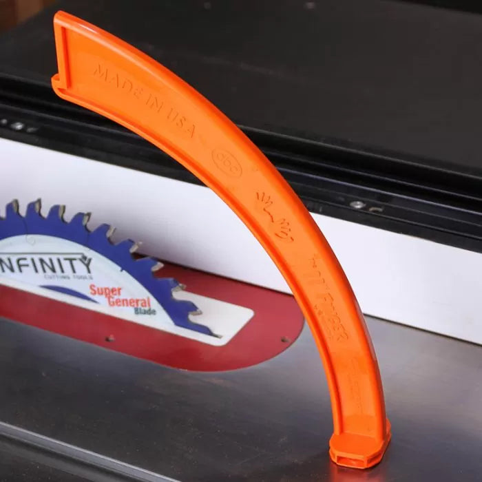 Orange plastic table saw blade guard on a table saw with visible saw blade
