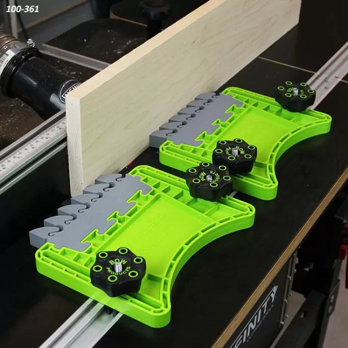 Green featherboard set securing wood on a router table for safe woodworking cuts