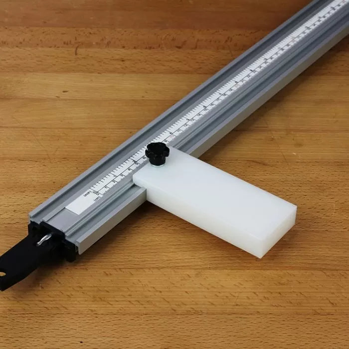 Aluminum woodworking stop track with adjustable block and ruler on wooden workbench