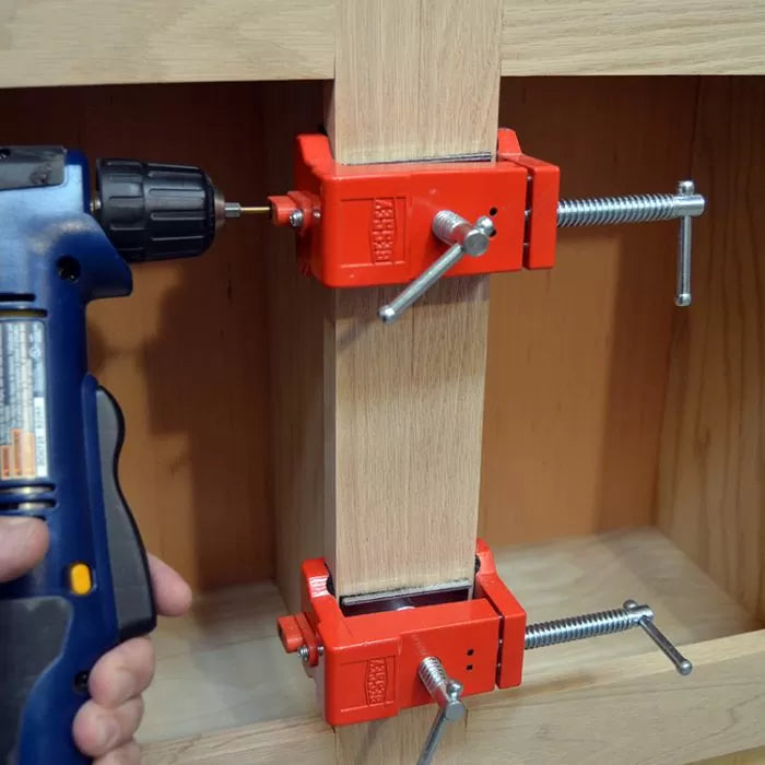 Woodworking dowel jig clamps holding wood with a drill driver in use