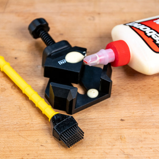 Corner clamp with glue and applicator on wood surface for woodworking projects