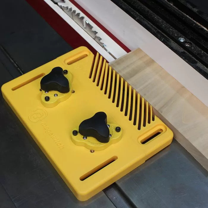 Yellow magnetic featherboard holding wood against table saw fence for woodworking safety