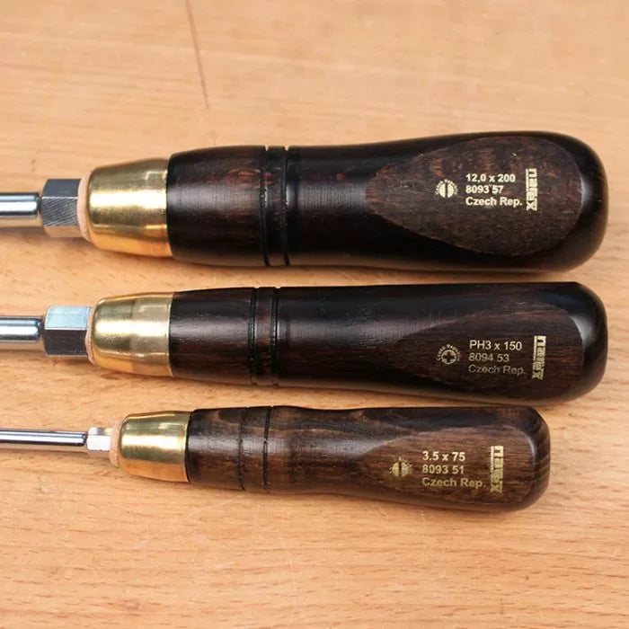 Set of three woodworking screwdrivers with dark wood handles and brass ferrules on a wood surface