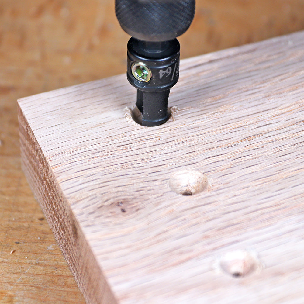 Countersink drill bit creating screw hole in wooden board for woodworking