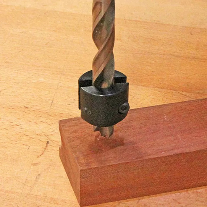 Drill bit with stop collar drilling into hardwood block on workbench, woodworking tool