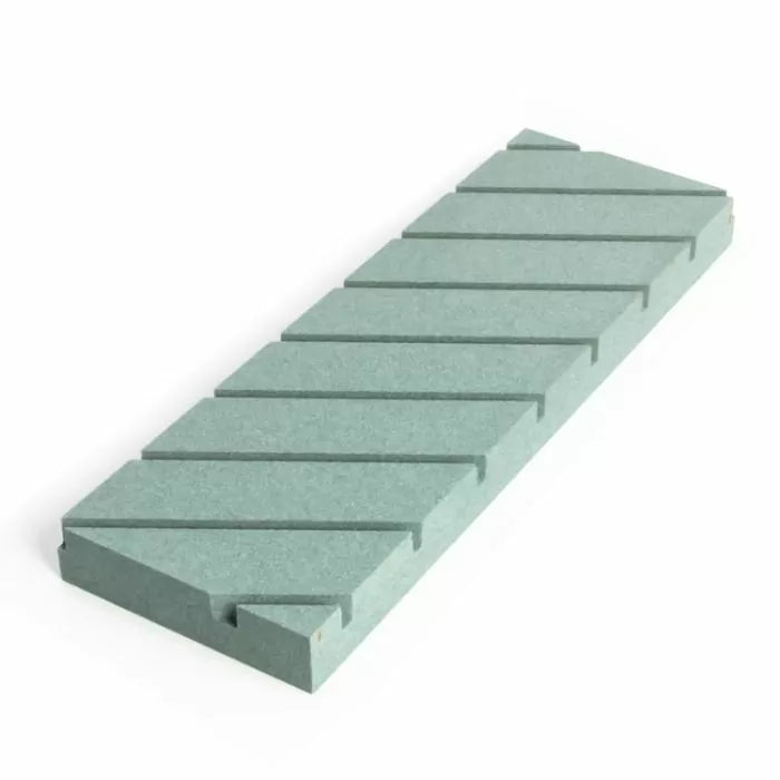 Rectangular green sharpening stone with diagonal grooves, used for woodworking tool honing.