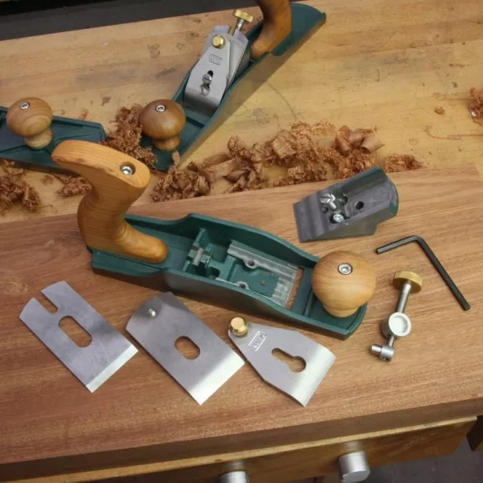 Wood hand plane with disassembled parts and accessories on a workbench with wood shavings