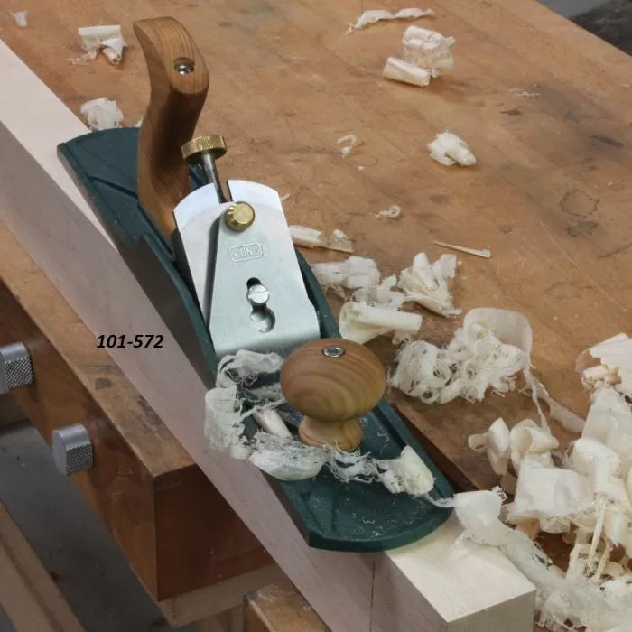 Bench hand plane with wooden handles on workbench, wood shavings and labeled 101-572