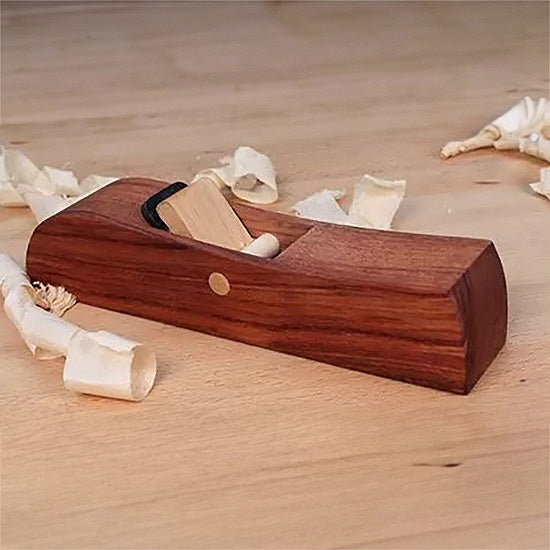 Wooden hand plane for woodworking with wood shavings on a workbench