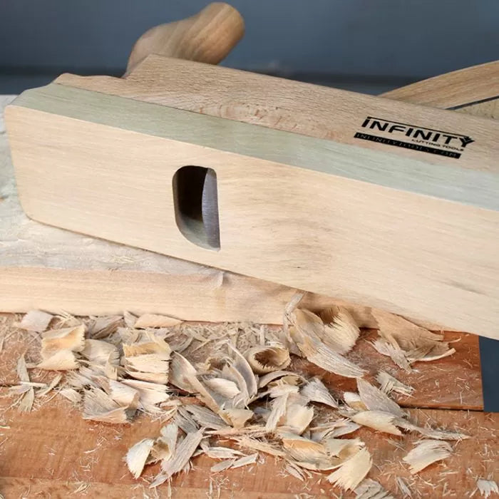 Wooden hand plane tool on a workbench with wood shavings, woodworking tool in use