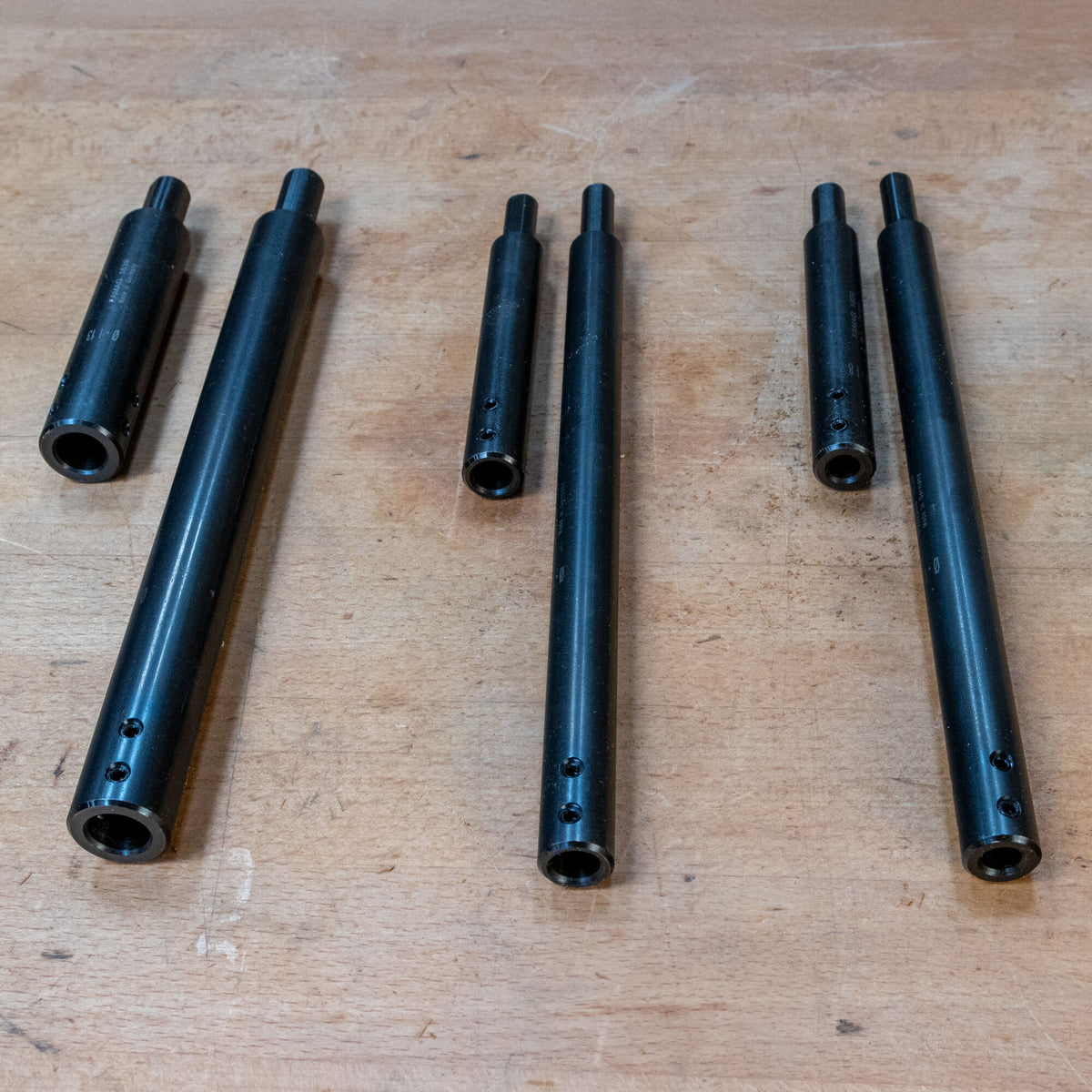 Three-piece set of black steel woodworking jig rods on a workbench