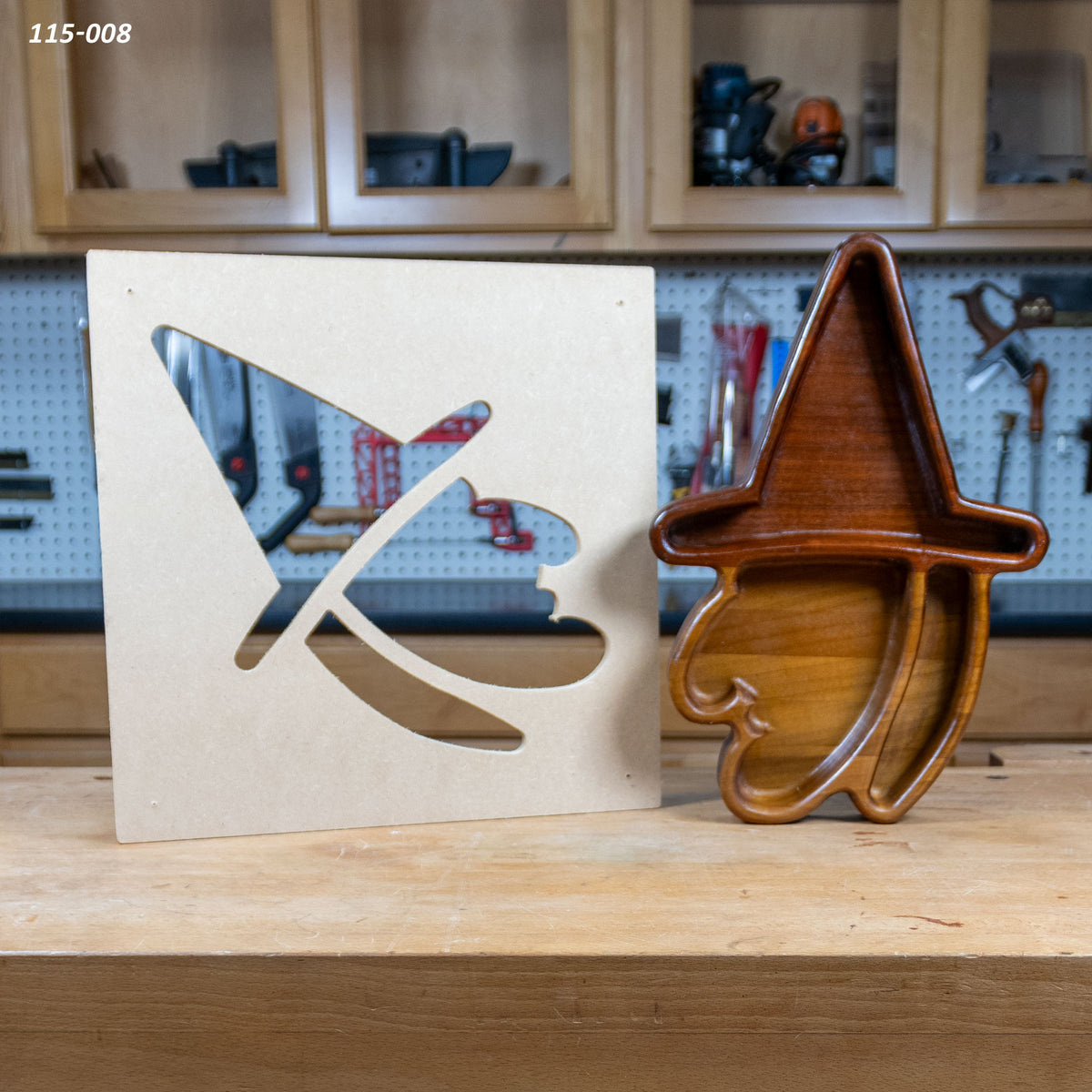 Wooden witch tray with matching MDF template for woodworking projects on a workbench.