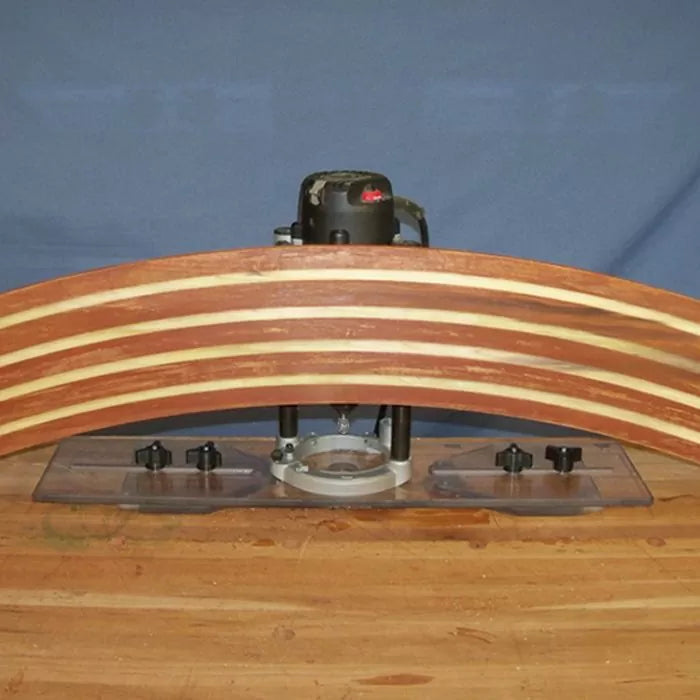 Woodworking router with straight edge guide shaping a curved laminated wood piece on workbench.