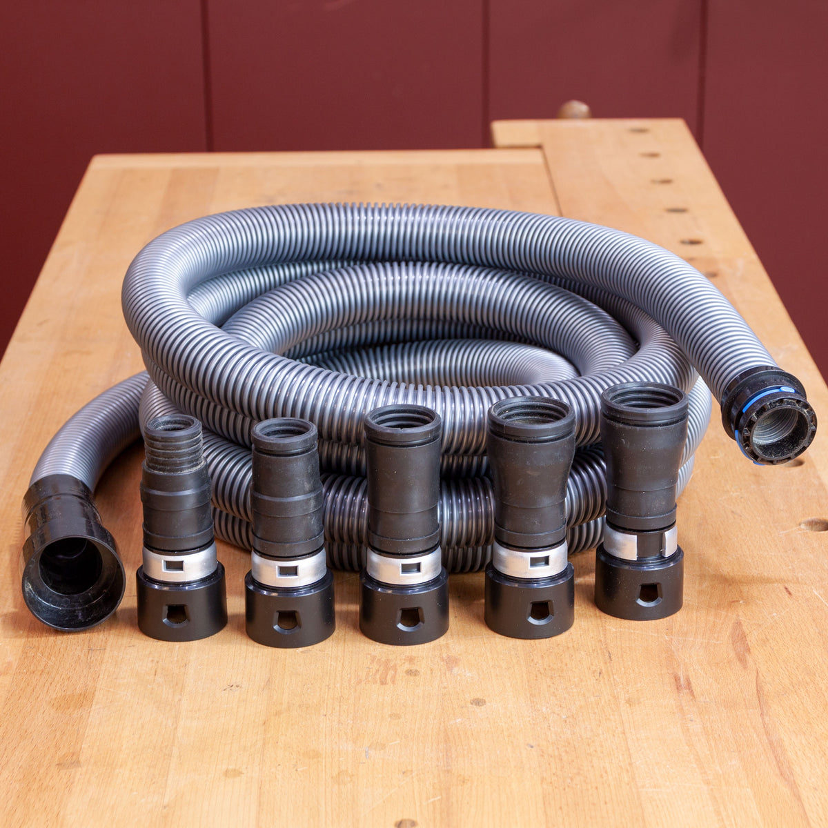 Quick snap adapters and a dust hose on a work bench.