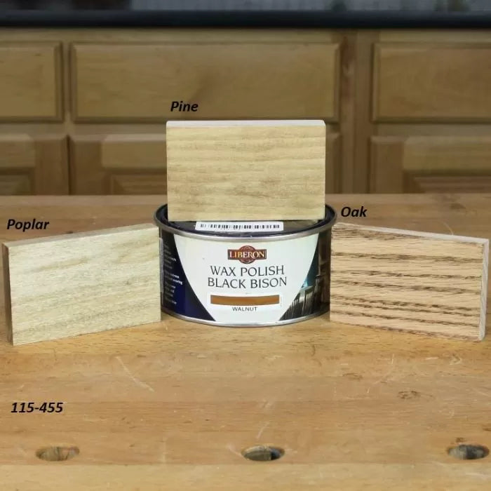 Wax polish can with labeled wood samples of pine, oak, and poplar on a workbench.