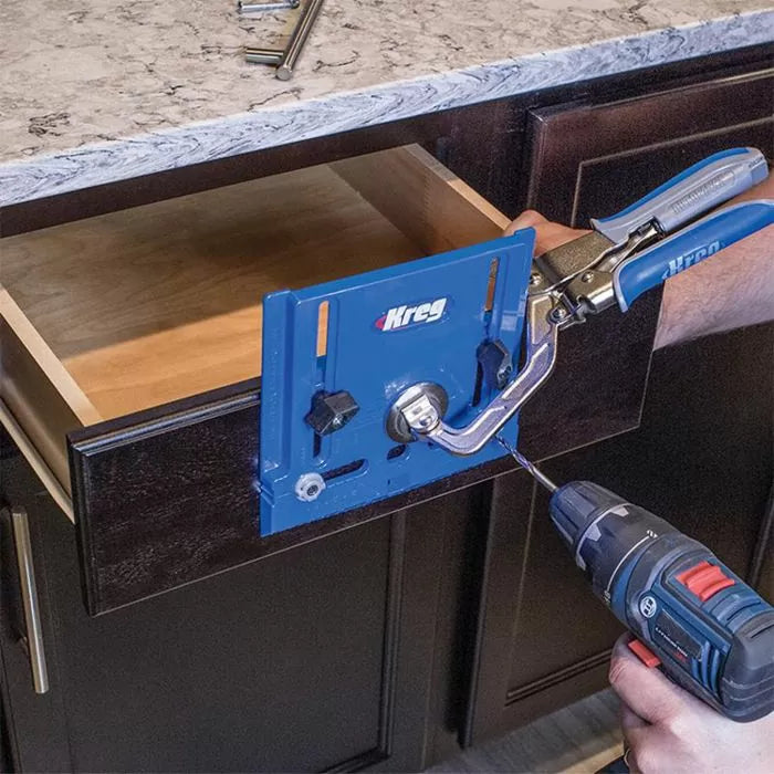 Drawer front being installed with a Kreg jig and a cordless drill on dark kitchen cabinetry