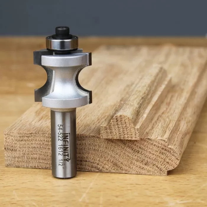 Woodworking router bit with roundover profile placed next to shaped wooden board