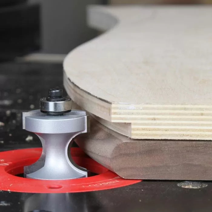 Woodworking router table with roundover router bit shaping plywood edge