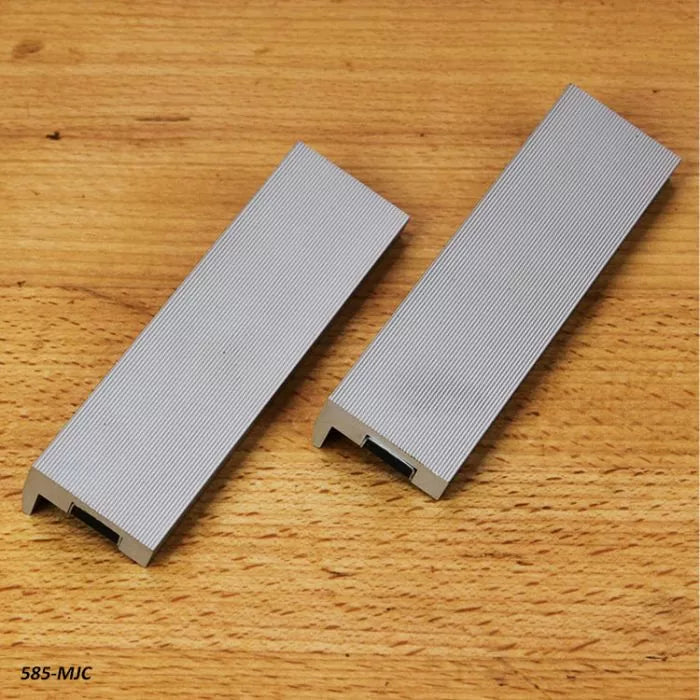 Pair of aluminum featherboard hold-downs for woodworking on a wooden surface