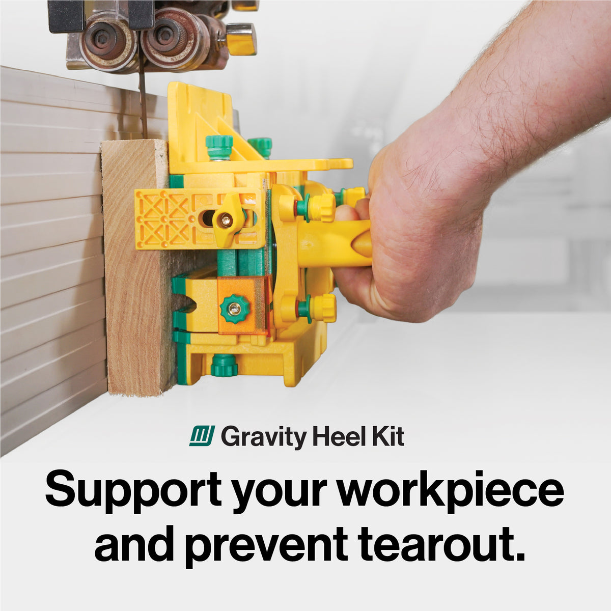 A hand operating a push block at the band saw.