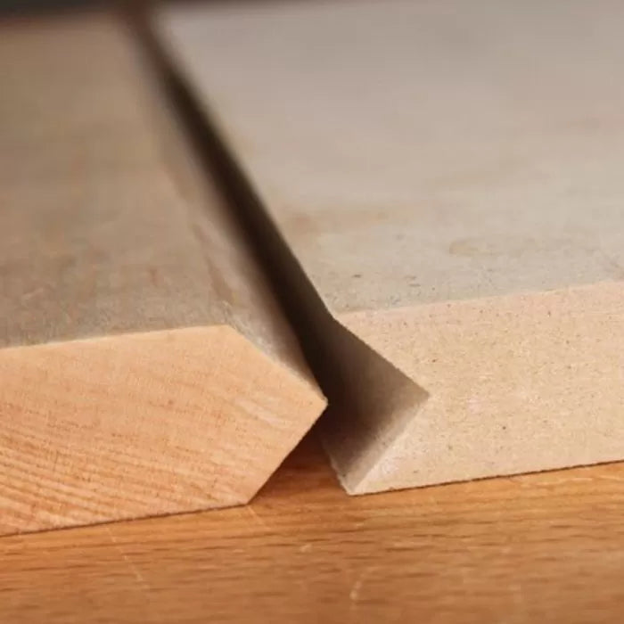 Close-up of two wooden boards with precise bevel cuts, showcasing woodworking tool results