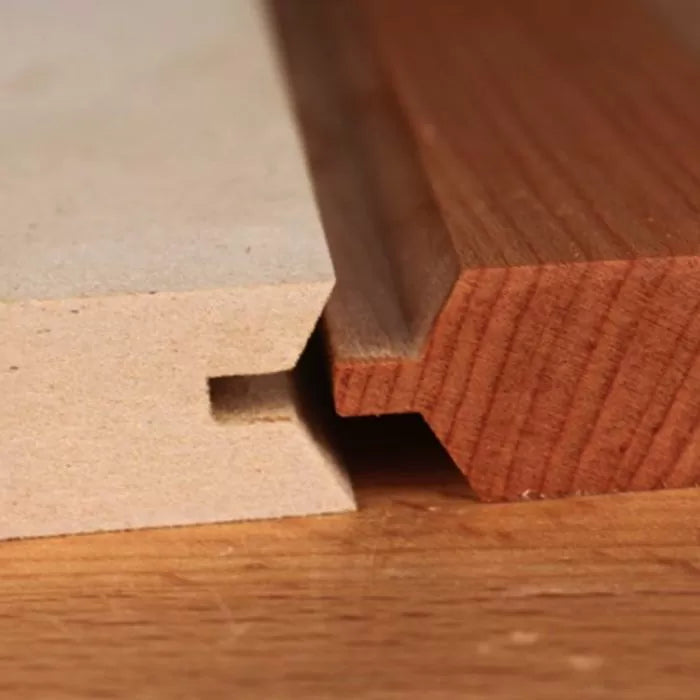 Close-up of two interlocking wooden boards with tongue and groove joinery for woodworking projects.