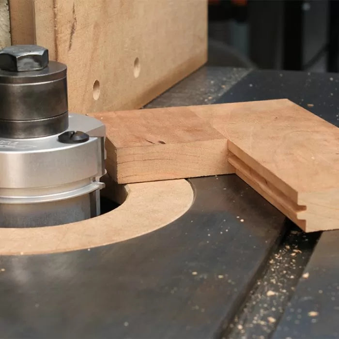 Router table with stacked router bit cutting grooves in wood for joinery
