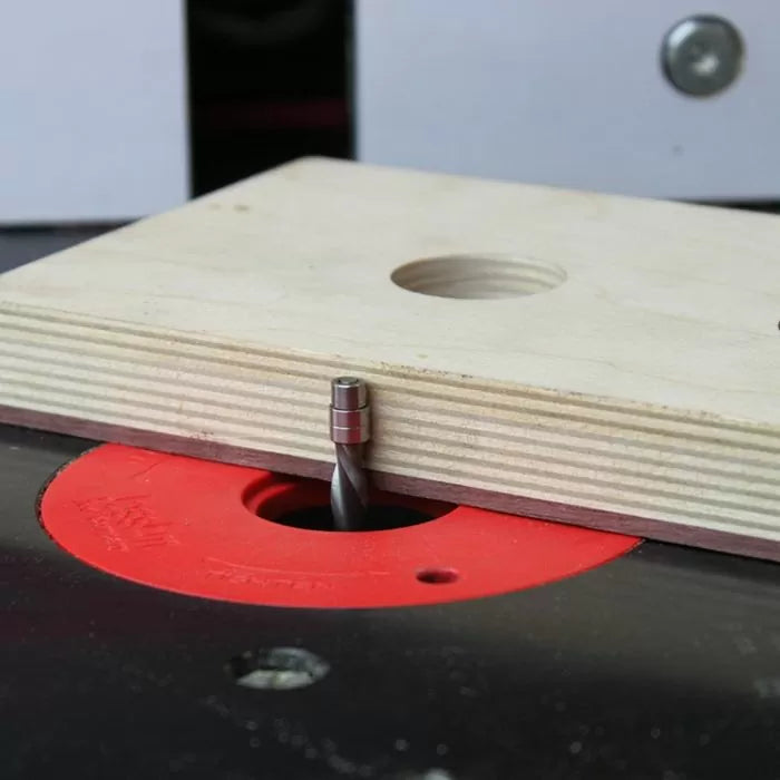 Router bit with bearing set up on a router table with plywood for woodworking precision