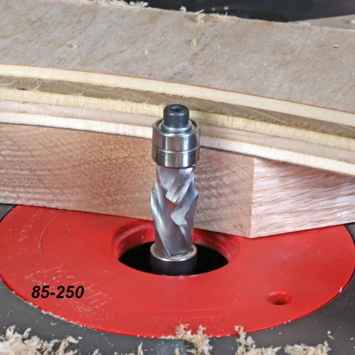 Router table with spiral flush trim bit cutting wood, woodworking tool in action