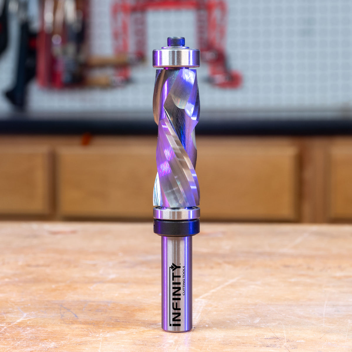 Solid carbide compression double bearing router bit on a workbench in a woodworking shop.