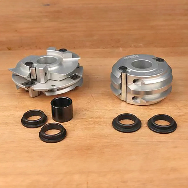 Woodworking router bit bushings and spacers on a wooden surface