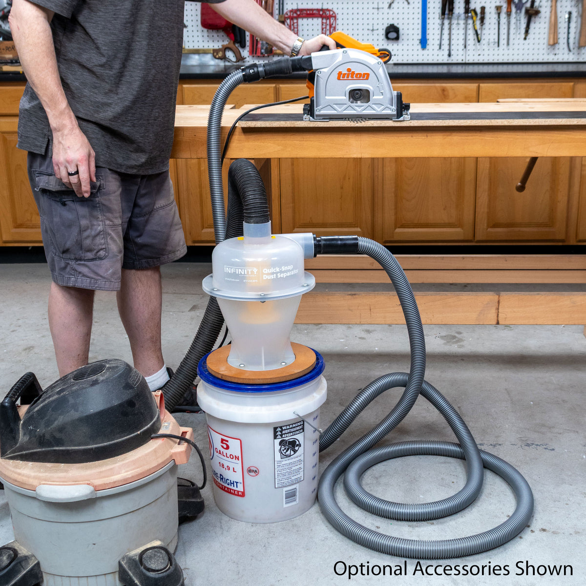 A person using a track saw attached to a dust separator in a wood shop.