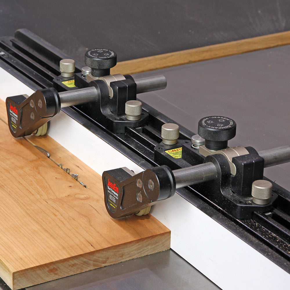 Table saw fence with adjustable featherboards guiding wood for precise cutting