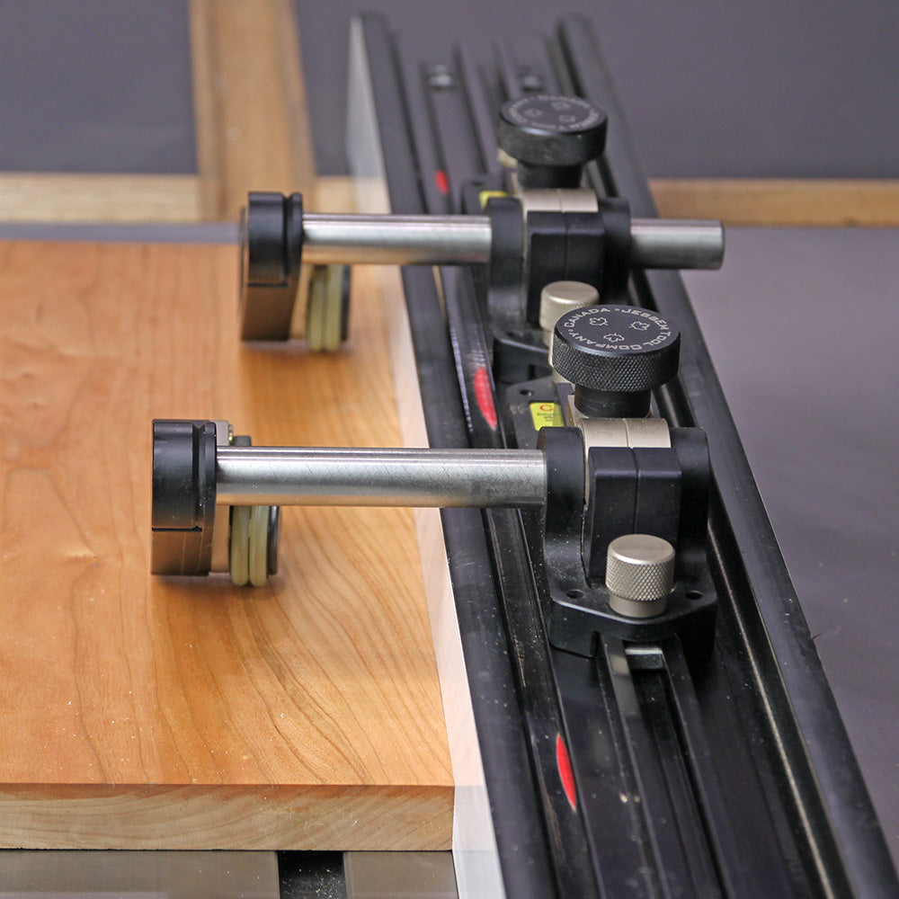 Precision woodworking featherboard and fence guide holding wood on a router table
