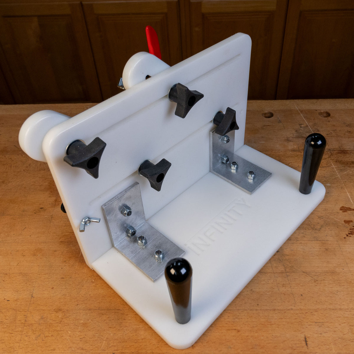 Vertical router sled jig with adjustable clamps and handles on a woodworking bench