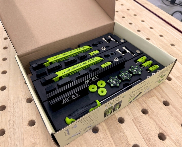 Bow low pro clamps set with accessories in an open box on a workbench