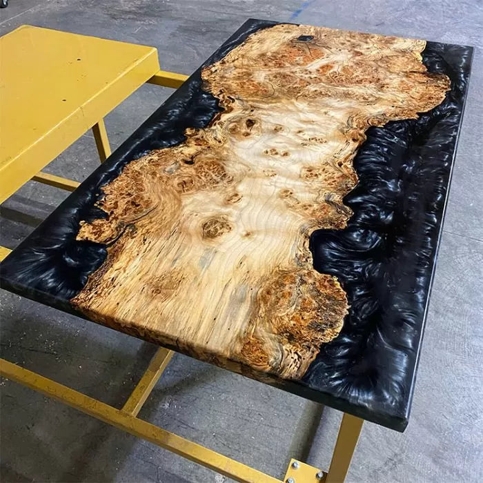 Live edge epoxy resin wood table on yellow workbench, woodworking project display