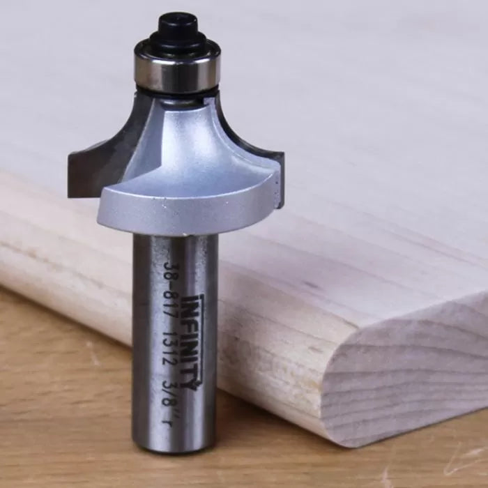 Roundover router bit next to finished wood edge on a workbench