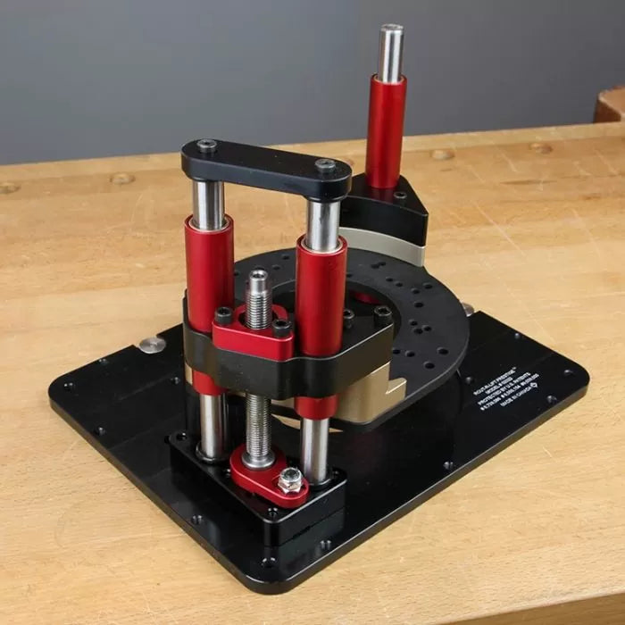 Precision router lift with red and black metal supports on a woodworking bench