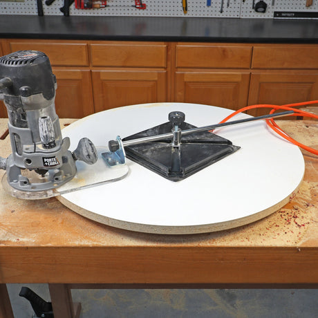 Porter-Cable router on a circle-cutting jig trimming a round tabletop on a workbench