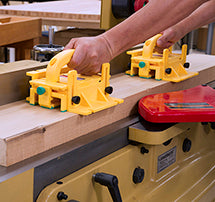 Yellow MicroJIG GRR-Ripper push blocks guiding a board across a jointer