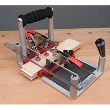Coping sled with toggle clamps holding a board for end-grain routing