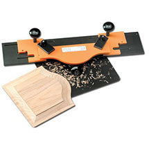 Orange router jig for arched panels next to a raised cathedral panel