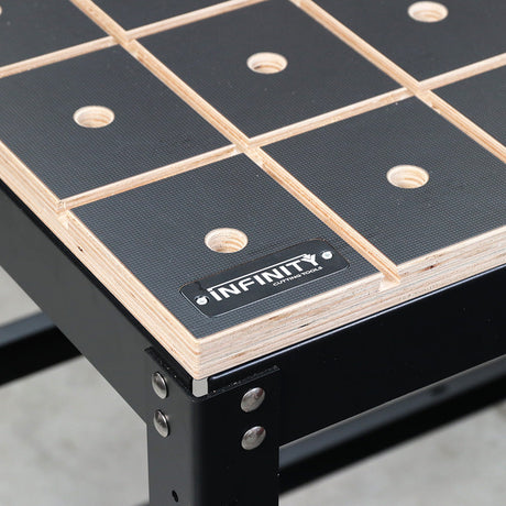 Corner of an Infinity dog hole worktop with grid of holes and track slots