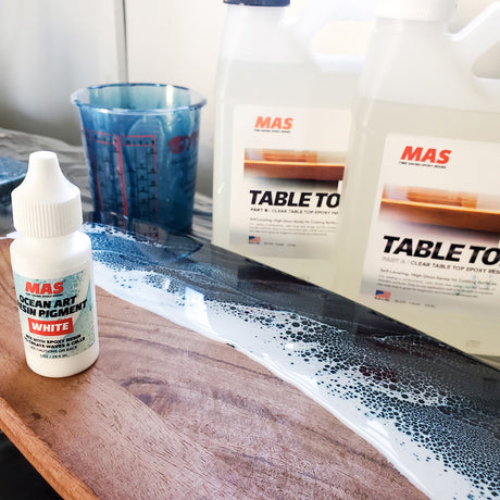 MAS Table Top epoxy jugs, Ocean Art resin pigment and mixing cup with a poured resin wave