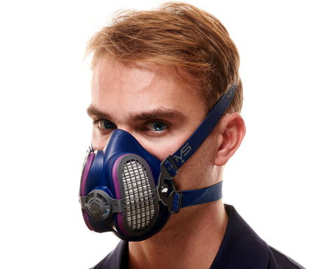 Woodworker wearing a blue half-mask respirator with P100 filter cartridges